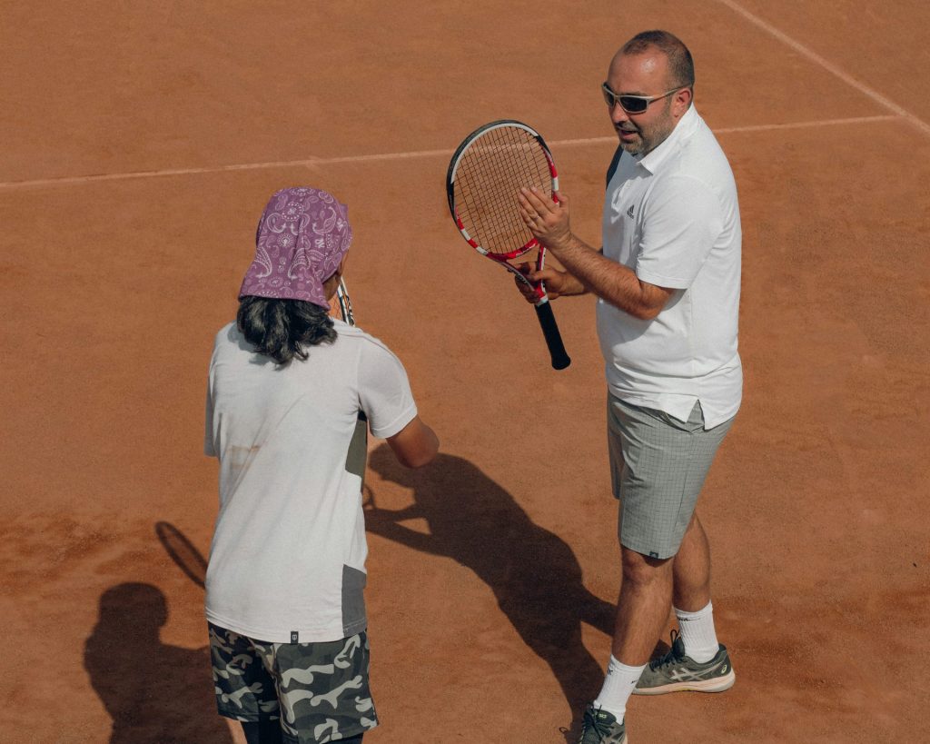a man and a woman holding tennis rackets
