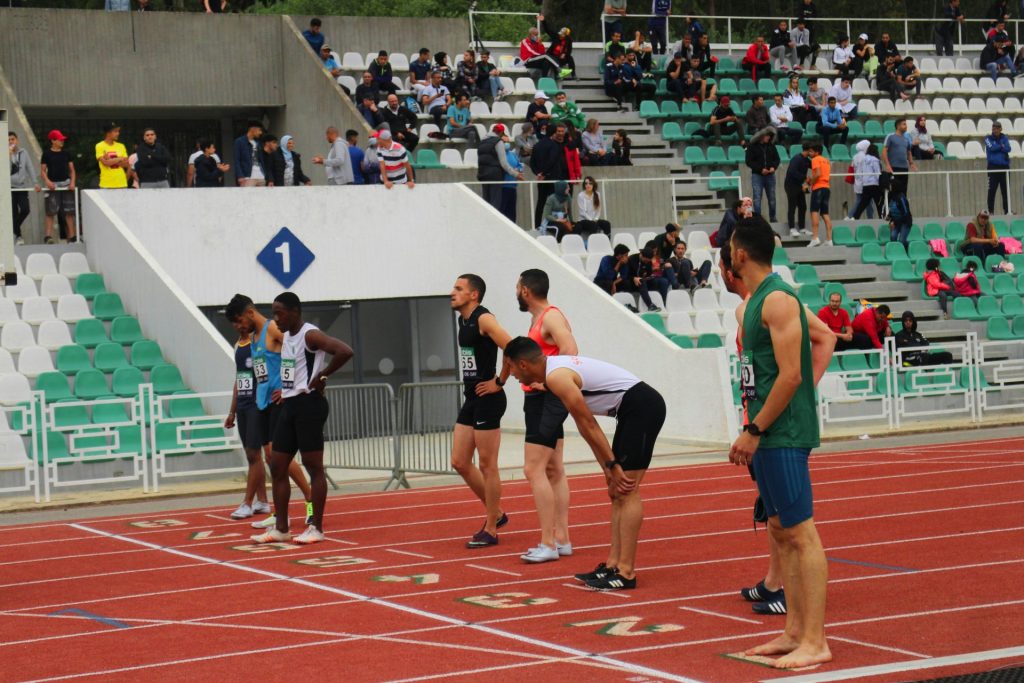 woman in green sports bra and black shorts running on track field